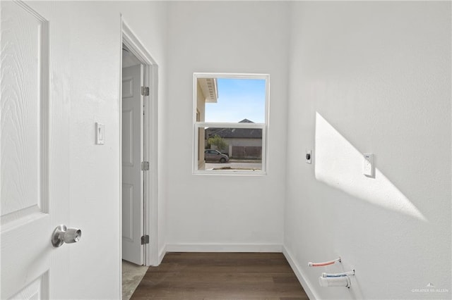 corridor with baseboards and wood finished floors