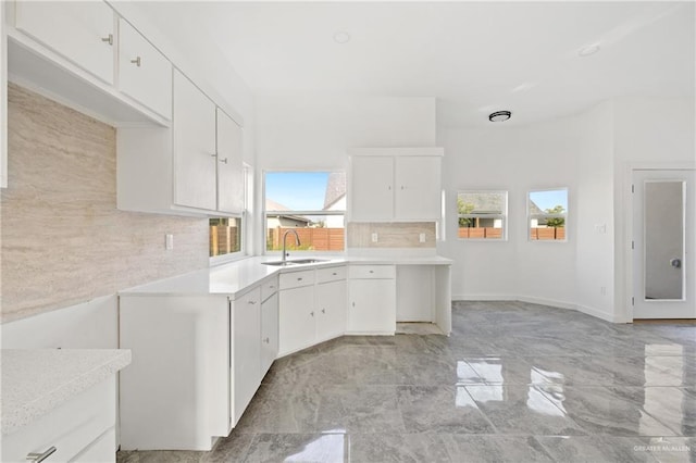 kitchen with white cabinets, light countertops, and a sink