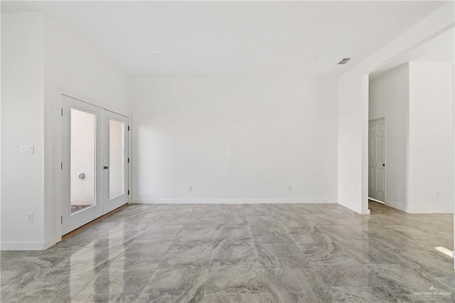 spare room featuring marble finish floor, visible vents, baseboards, and french doors