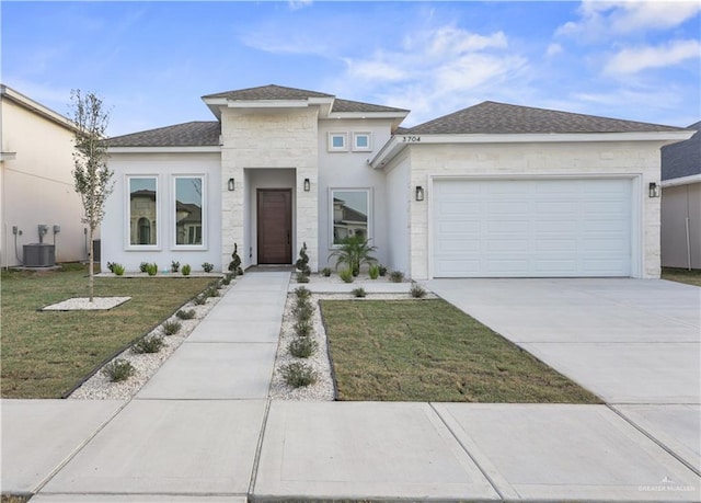 prairie-style home with driveway, roof with shingles, an attached garage, central AC, and a front lawn