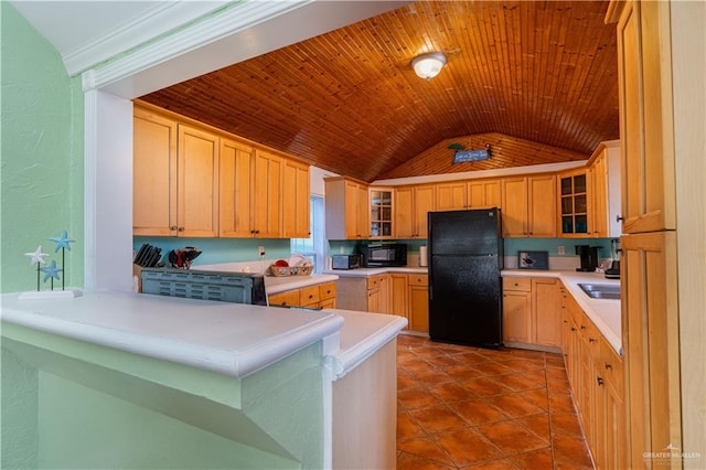 kitchen featuring sink, tile patterned floors, kitchen peninsula, vaulted ceiling, and black appliances