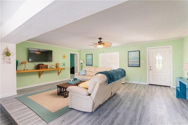 living room with ceiling fan, crown molding, and hardwood / wood-style flooring