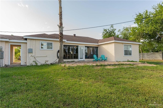 rear view of property with a yard and a patio area