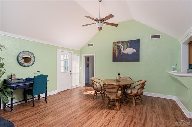 dining space with hardwood / wood-style floors, vaulted ceiling, ceiling fan, and ornamental molding