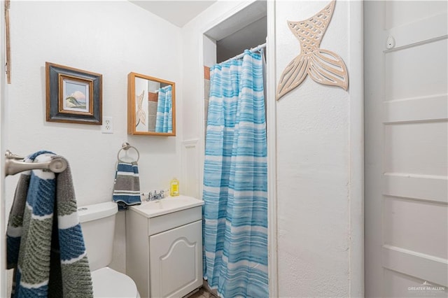 bathroom featuring vanity, toilet, and walk in shower