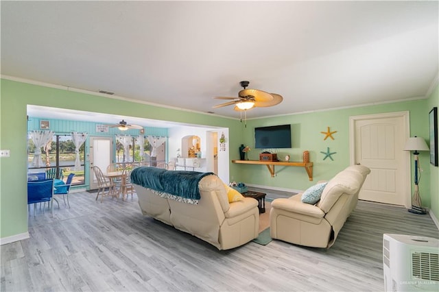 living room with ceiling fan, ornamental molding, and light wood-type flooring