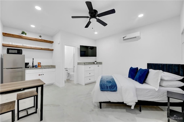 bedroom featuring a wall unit AC, stainless steel refrigerator, ceiling fan, and ensuite bathroom