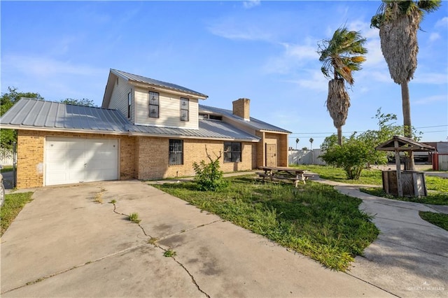 3401 Del Norte Dr, Mission, TX 78574 - view of front of home featuring an attached garage, brick siding, driveway, and metal roof