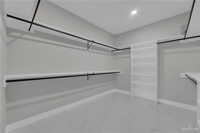 walk in closet featuring marble finish floor