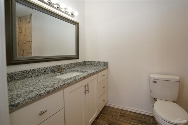 bathroom with vanity, hardwood / wood-style flooring, and toilet