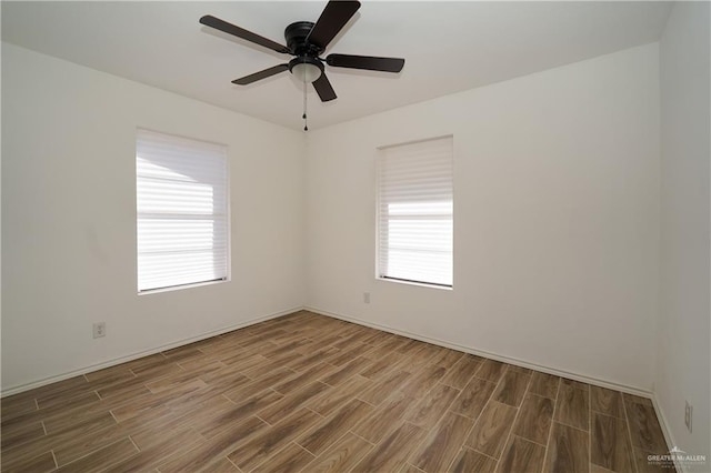 spare room with a wealth of natural light, ceiling fan, and hardwood / wood-style flooring