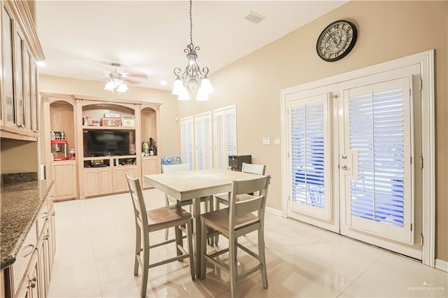 tiled dining area featuring ceiling fan with notable chandelier