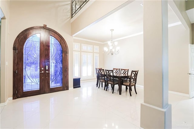 foyer featuring a chandelier, light tile patterned floors, crown molding, and french doors