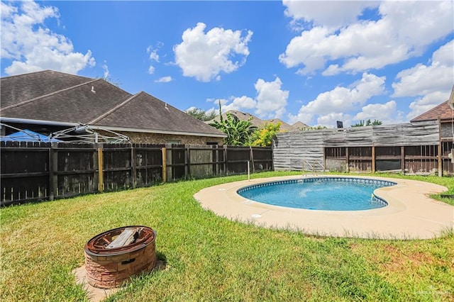 view of swimming pool with a fire pit and a lawn