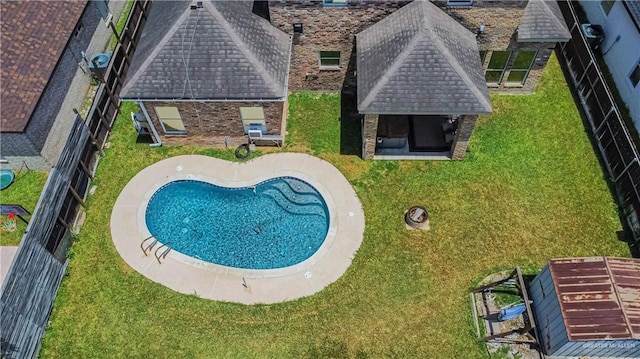 view of swimming pool with a yard