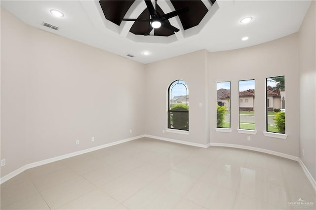 empty room with a tray ceiling and ceiling fan