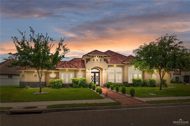 mediterranean / spanish-style home with a yard