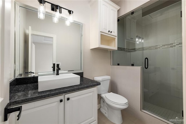 bathroom with tile patterned floors, vanity, toilet, and an enclosed shower