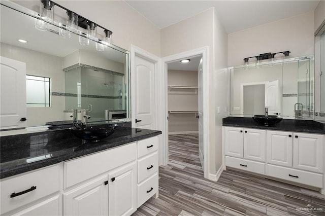 bathroom with vanity, a shower with shower door, and hardwood / wood-style flooring