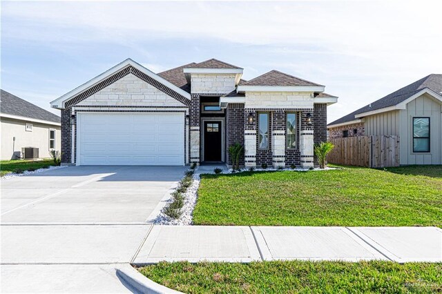 8801 Swan Lake Dr, Harlingen, TX 78550 - view of front of property featuring an attached garage, cooling unit, fence, concrete driveway, and a front yard