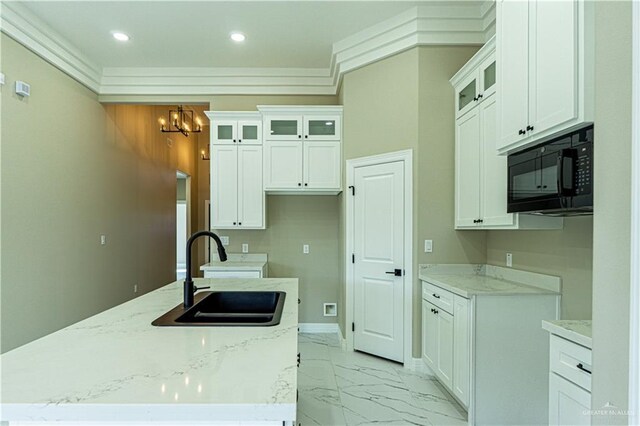 8801 Swan Lake Dr, Harlingen, TX 78550 - kitchen featuring white cabinets, light stone counters, marble finish floor, black microwave, and a sink