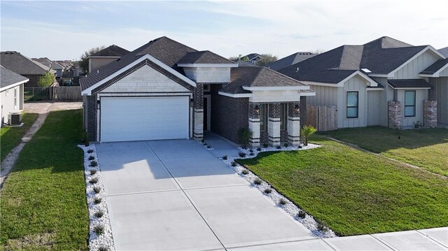 8801 Swan Lake Dr, Harlingen, TX 78550 - view of front of home with a garage, central AC, concrete driveway, board and batten siding, and a front yard