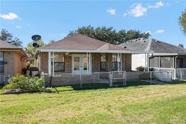 view of front of house featuring a front yard, ceiling fan, and a sunroom