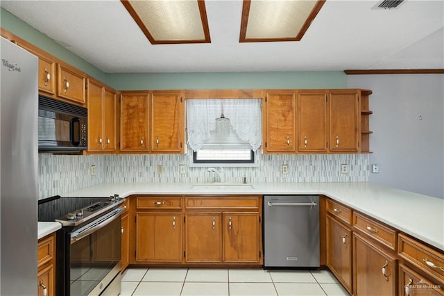 kitchen with sink, light tile patterned floors, tasteful backsplash, kitchen peninsula, and stainless steel appliances