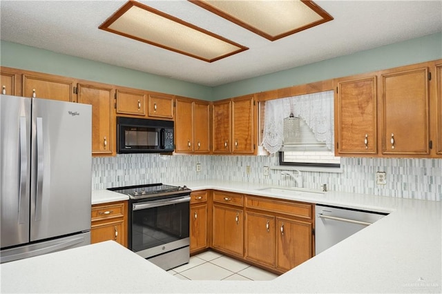 kitchen featuring appliances with stainless steel finishes, backsplash, light tile patterned floors, and sink