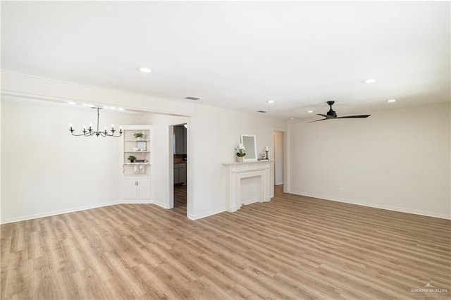 unfurnished living room with ceiling fan with notable chandelier and light wood-type flooring