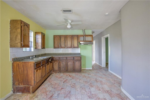 kitchen featuring ceiling fan, sink, and backsplash