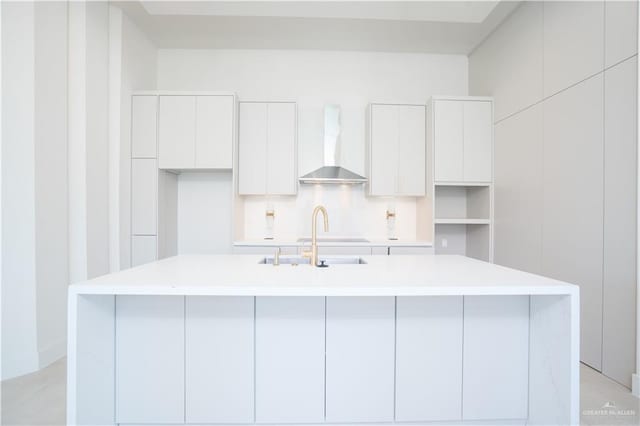 2607 Cottonwood St, Mission, TX 78574 - kitchen featuring wall chimney exhaust hood, a center island with sink, a sink, white cabinetry, and modern cabinets