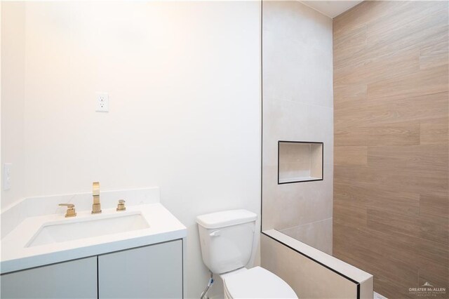 2607 Cottonwood St, Mission, TX 78574 - bathroom featuring toilet, vanity, and a tile shower