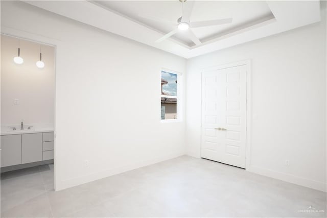 2607 Cottonwood St, Mission, TX 78574 - unfurnished bedroom featuring a sink, a tray ceiling, baseboards, and a ceiling fan