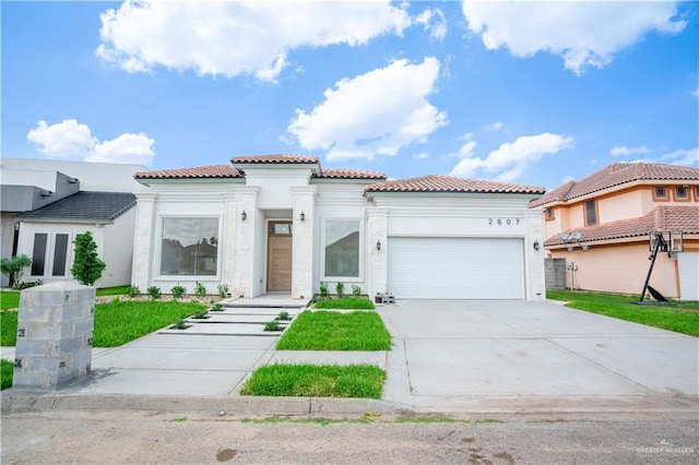 2607 Cottonwood St, Mission, TX 78574 - mediterranean / spanish-style house featuring a garage, a tiled roof, driveway, stucco siding, and a front lawn