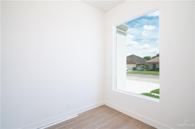 2607 Cottonwood St, Mission, TX 78574 - unfurnished room with baseboards, wood finished floors, and healthy amount of natural light
