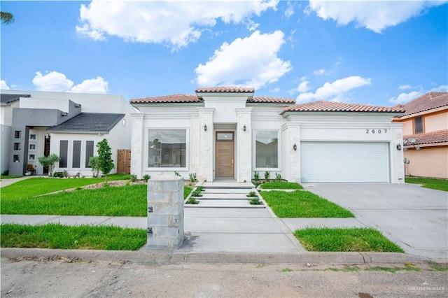 2607 Cottonwood St, Mission, TX 78574 - mediterranean / spanish-style house featuring a tile roof, a garage, stucco siding, concrete driveway, and a front lawn
