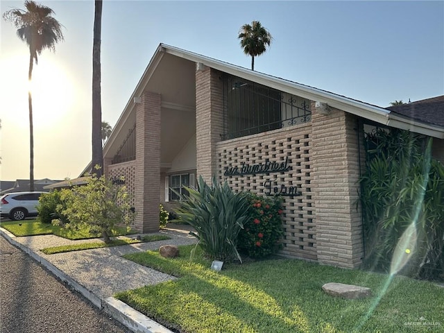 property exterior at dusk featuring a lawn