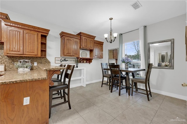 interior space featuring an inviting chandelier, baseboards, light tile patterned floors, and visible vents