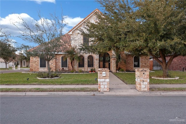 view of front of property with brick siding and a front yard