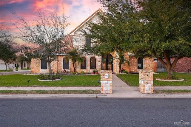 view of front of house featuring a front lawn and brick siding