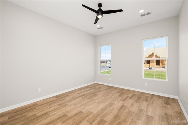 spare room with ceiling fan and light wood-type flooring