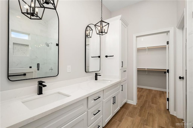 bathroom with hardwood / wood-style flooring, vanity, an enclosed shower, and a chandelier