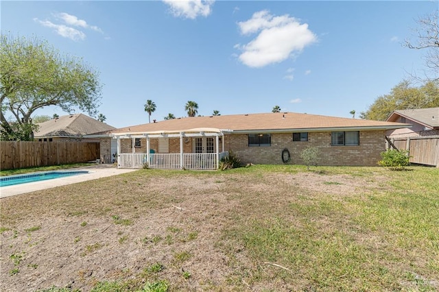 back of house with a fenced in pool, a yard, a fenced backyard, a patio area, and brick siding