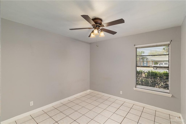 unfurnished room featuring light tile patterned floors, a ceiling fan, and baseboards