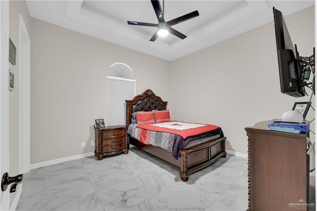 bedroom featuring a raised ceiling and ceiling fan