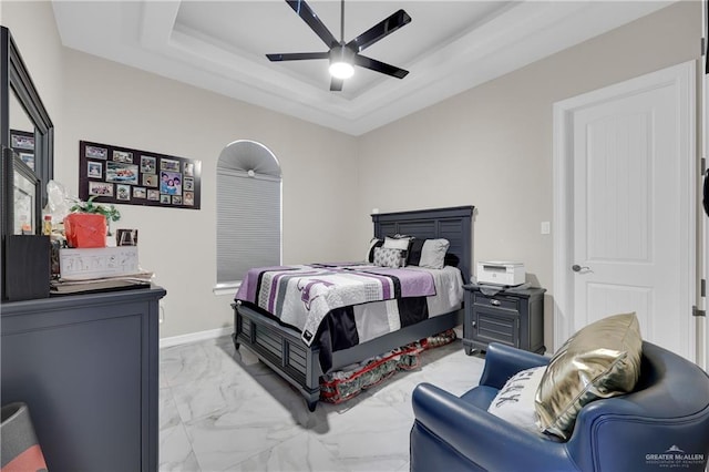 bedroom with a tray ceiling and ceiling fan