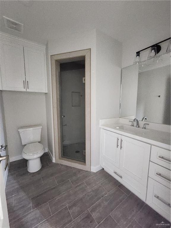 bathroom featuring an enclosed shower, vanity, and toilet