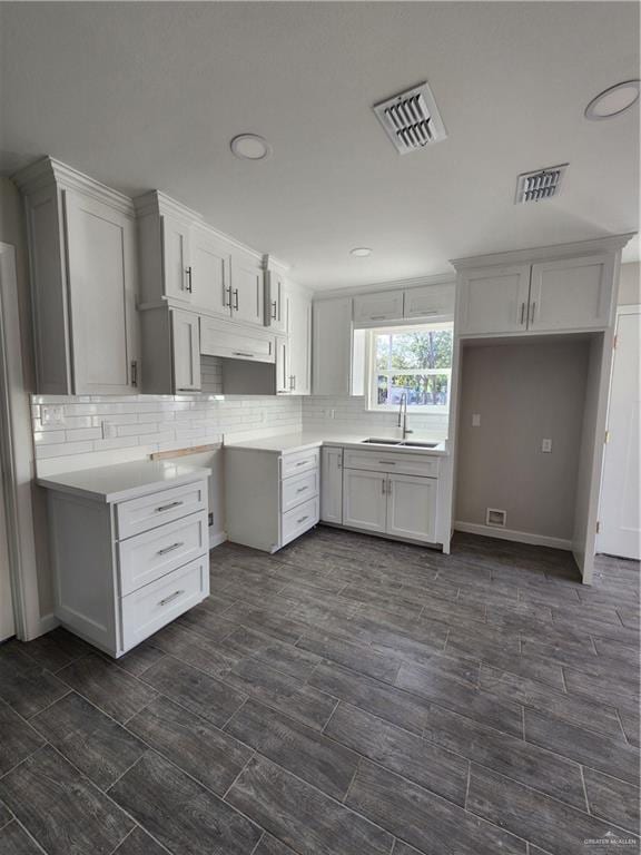 kitchen featuring backsplash, white cabinetry, and sink