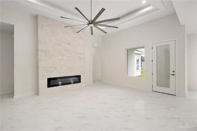 unfurnished living room with ceiling fan and a large fireplace